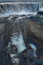 Selfoss waterfall with mud patterns in foreground, Iceland, August.