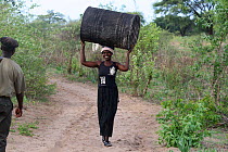 Woman carrying oil drum, Lozi People, Sioma Nqwezi Park, Zambia. November 2010.