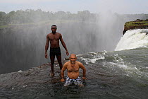 Steve O Taylor and a guide standing at the edge of Victoria Falls, Zambia, November 2010.