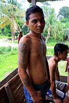 Dayak man with non traditional tattoo. Central Kalimantan,  Indonesian Borneo. June 2010.