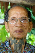 Dayak headhunter man with traditional tattoos, Dayak, Central Kalimantan,  Indonesian Borneo. June 2010.