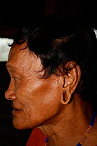 Dayak man with stretched ears, rehoused by government for dam building project. Sabah, Malaysian Borneo. July 2010.