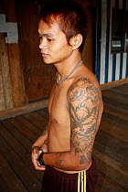 Dayak man, with western style tattoos, rehoused by government for dam building project, Sabah, Malaysian Borneo. July 2010.