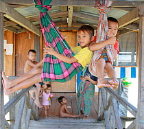Dayak people, children playing in longhouse, evicted from home for dam construction, Sabah, Malaysian Borneo. July 2010.