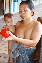 Dayak people, woman with baby, evicted from home for dam construction, Sabah, Malaysian Borneo. July 2010.