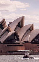 Small boat sailing beneath the Sydney Opera House, Sydney, New South Wales, New South Wales, Australia, November 2012.