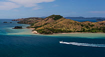 Aerial view of power boat sailing past Hamilton Island, in the Whitsunday Island group, Queensland, Australia. November 2012.