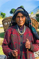 Elderly farmer carrying basket on her back, Ghandruk, Modi Khola Valley, Himalayas, Nepal. November 2014.