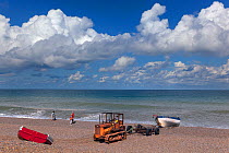 Tractor pulling small crab boat ahore, Weybourne beach, Norfolk, England, UK. August 2014.