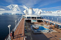 Cruise ship in front of snow covered mountains, Paradise Bay, Antarctica, January.