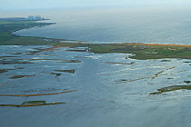 Aerial view of Steart Marshes Wildfowl and Wetland Trust Nature Reserve with Hinkley Point nuclear power station in background, Somerset, UK, February 2015. This area has been allowed to flood by the...