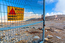 Gate with danger sign warning of land mines, Mount Hermon, Golan Heights, Israel, November.