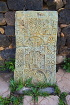 Cross-stone (khachkar) placed along church wall, Armenia, May.