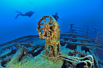 Divers by steering wheel of the Imperial Eagle wreck, a ferry sunk in 1999 in Qawra Point as an artificial reef, Malta, Mediterranean Sea. June 2014.