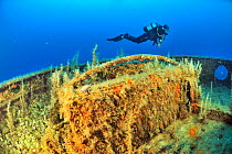Diver diving the wreck of the tug boat Rozi scuttled in 1992 off Cirkewwa, Malta, Mediterranean Sea. June 2014.