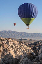 Hot air balloons above eroded limestone ravine, Cappadocia, Turkey, March 2006.