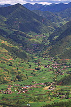 Mountain landscape with town and terraced fields, Lijiang Laojunshan National Park, Yunnan, China, July 2007.