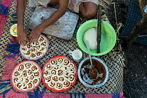Man from Ligau Levu Village preparing roly poly bread with sweetend grated coconut for breakfast, Mali Island, Macuata Province, Fiji, South Pacific. August 2013