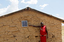 Installation of solar cell unit into a Masai clay hut. Mara-region, Kenya, March 2013.