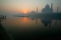 Taj Mahal at sunset, reflected in water, Agra, India.