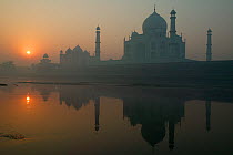 Taj Mahal in mist at sunset, reflected in water, Agra, India.