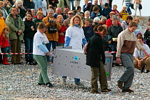 Volunteers carrying rehabilitated Harbour seal (Phoca vitulina) to the shore to be released, watched by spectators. Bay of Somme, France, 3rd October 2004.