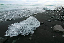 Ice washed up on volcanic sand beach near Jokulsarlon, Iceland, August.