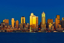 Sunset reflected  off  skyscrapers, viewed from across Elliott Bay, West Seattle, Washington, USA. December 2014.