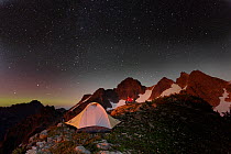Campsite at night, with light pollution from nearby city,, below Three Fingers Lookout, Boulder River Wilderness, Mount Baker, Washington, USA. August 2014. Model released.