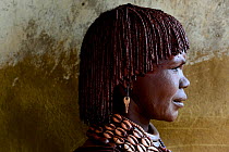 Profile portrait of Hamer woman with traditional ornaments and braided hair covered in ochre and butter, Territory of the hamer tribe. Lower Omo Valley. Ethiopia, November 2014