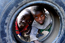 Children playing with the tyre of a wheel. Ari village. Omo Valley. Ethiopia, November 2014