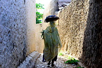 Muslim woman walking down narrow streets, Harar, an important holy city in the Islamic faith, UNESCO World Heritage Site. Ethiopia, November 2014