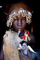 Dassanech girl with headdress of nuts and bolts, holding goat, Dassanech tribe, Lower Omo Valley. Ethiopia, November 2014