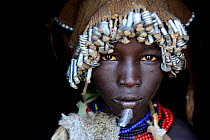 Dassanech girl with headdress of nuts and bolts, and feather on chin, Dassanech tribe, Lower Omo Valley. Ethiopia, November 2014