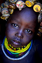 Dassanech baby with her headdress made from bottlecaps, Lower Omo Valley. Ethiopia, November 2014
