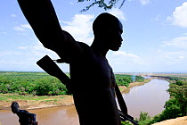 Karo man with gun next to the Omo river, Karo tribe. Omo river. Ethiopia, November 2014