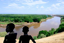 Karo women with traditional adornaments looking over the Omo river, Ethiopia, November 2014