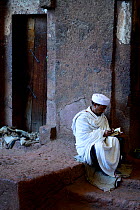 Priest reading bible in Bet Meskel church (part of the northwestern group of churches in Lalibela). UNESCO World Heritage Site. Lalibela. Ethiopia, December 2014.