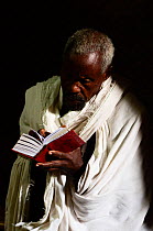 Priest reading Bible in Bet Maryaml church (part of the northwestern group of churches in Lalibela). UNESCO World Heritage Site. Lalibela. Ethiopia, December 2014.