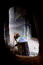 Christian woman praying, Bet Danaghel (part of the northwestern group of churches in Lalibela). UNESCO World Heritage Site. Lalibela. Ethiopia, December 2014.