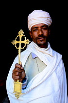 Priest of Bet Giyorgis Church holding golden cross. Lalibela. UNESCO World Heritage Site. Ethiopia, December 2014.