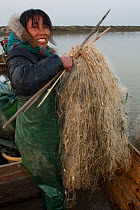 Fisherwoman mending her nets, Changshan Island, Poyang Ho Lake, Jiangxi province, China, December 2014.