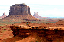 Navajo man riding horse in front of rock formations of Monument Valley, Utah, USA, May 2014.