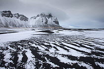 View across snow covered beach towards Vesturhorn, South Iceland. March 2014.