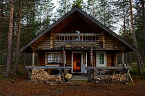 Log cabin in coniferous woodland, Lapponia, Finland, June 2015.