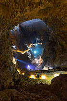 Tourists looking down onto underground stream, from illuminated pathway, Skocjan Caves, Green Karst, Slovenia, October 2014.