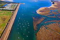 Aerial view of  boats in East Fleet, with Pinewoods caravan park, and salt marshes on the coast of Norfolk, England, UK, February 2009.