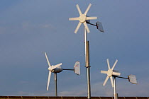 Domestic wind turbines on houses without mains electricity, The Wash, Snettisham, Norfolk, England, UK, February 2015.