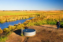 Lynn Ballagh inspecting water well on his cattle ranch in the Sandhills of Nebraska, Garfield County, Nebraska, USA. October 2014.