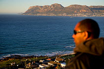 Shark spotter looking out to sea on the side of mountain above Kalk Bay, False Bay, near Cape Town, Western Cape, South Africa. July 2013.